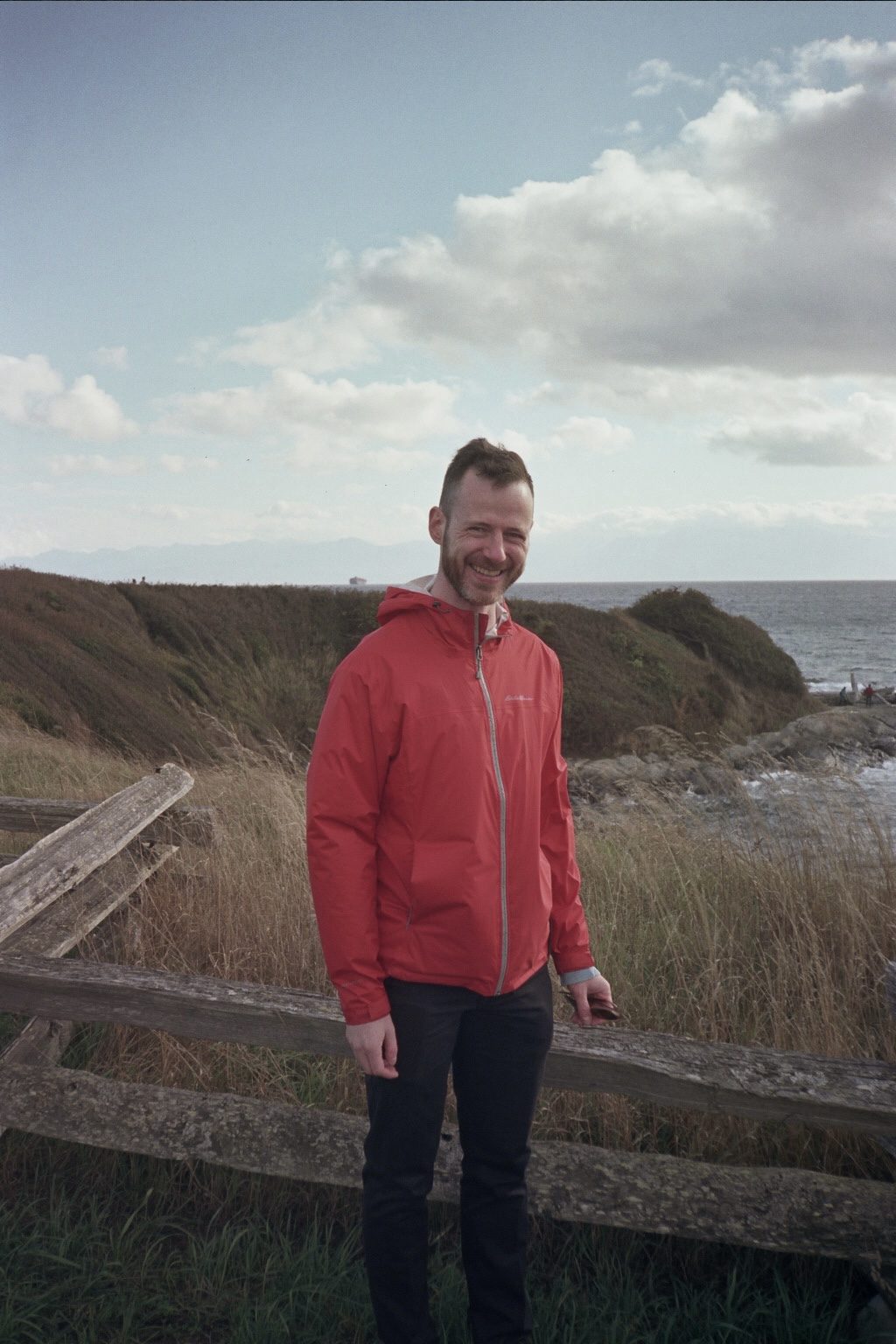 Figure in red jacket by ocean