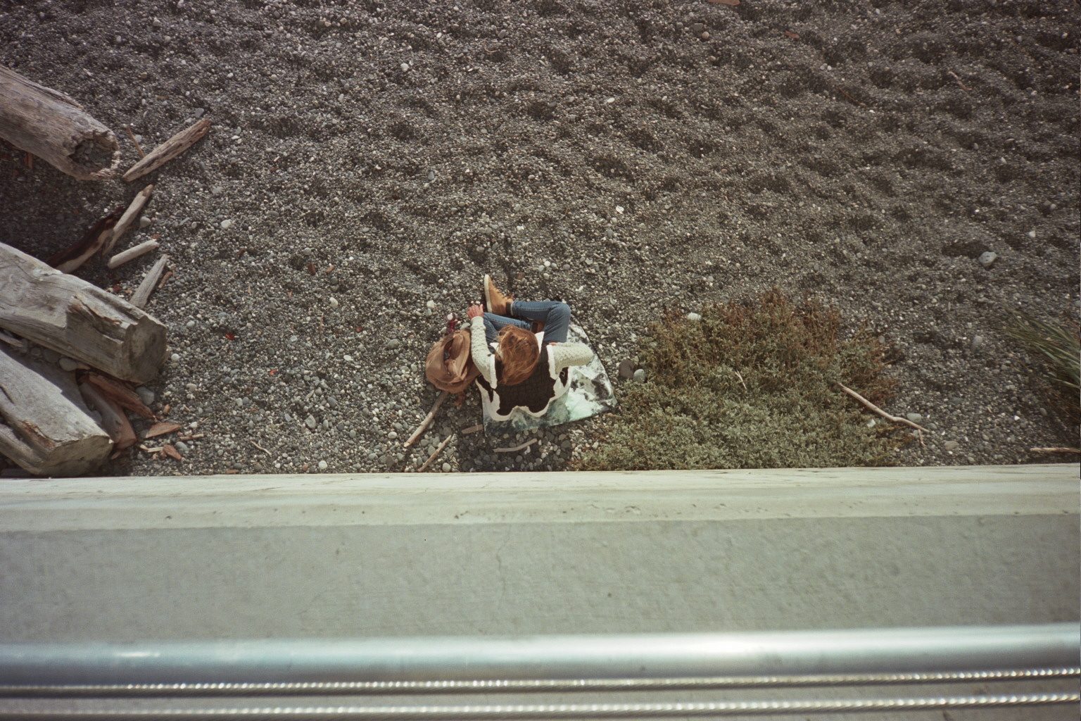 Figure resting on beach gravel