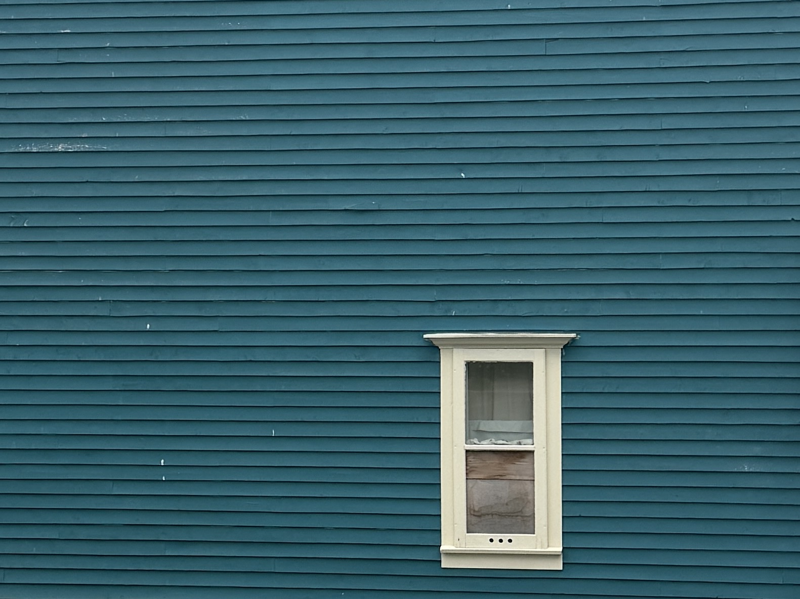 Teal clapboard with cream window