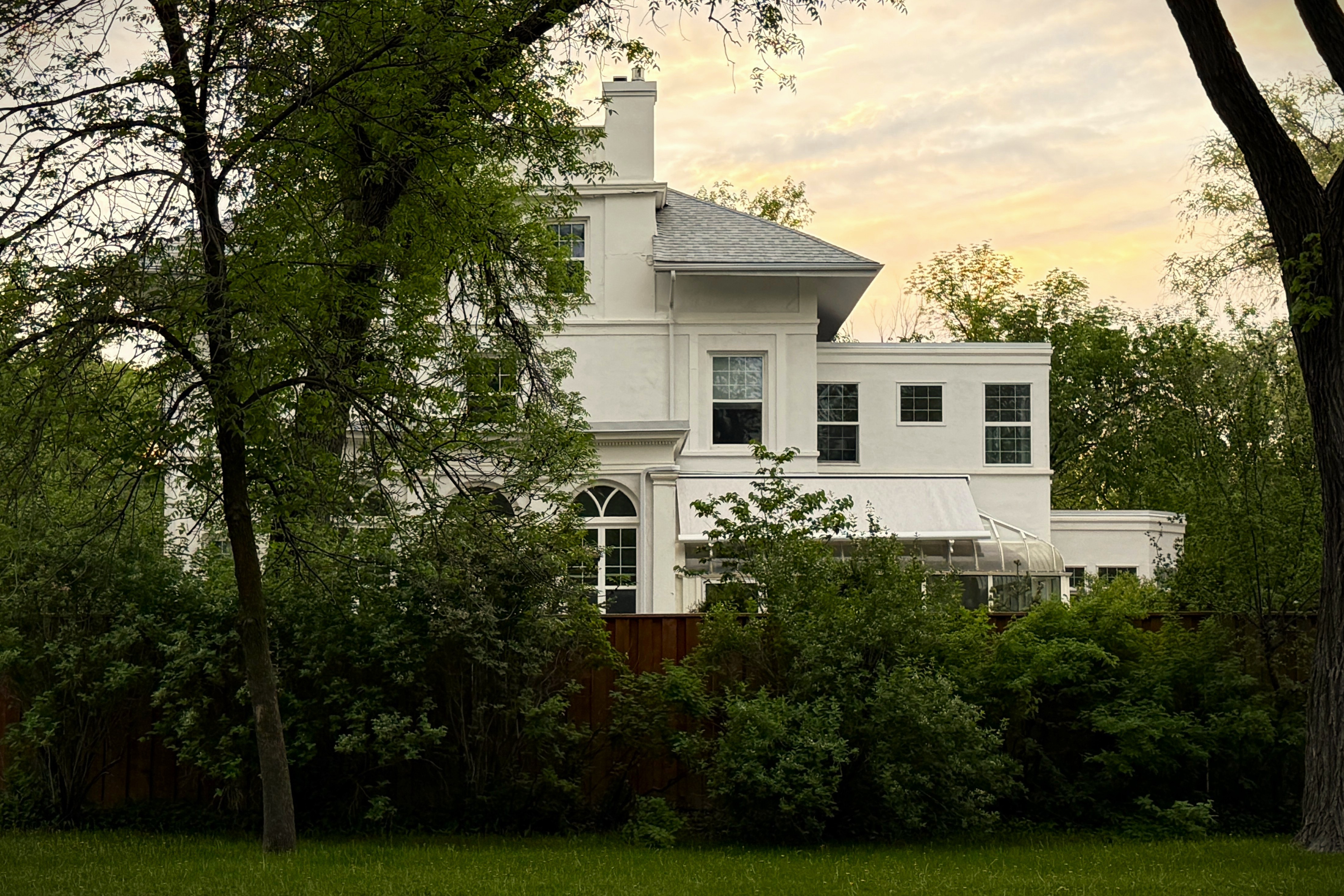 White house at dusk through trees